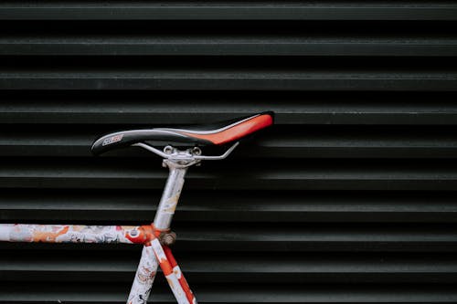 검은 금속 벽에 빨간색과 흰색 자전거