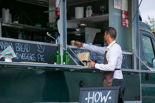 A man serves food from a street truck in an outdoor setting. Perfect for lifestyle and hospitality themes.