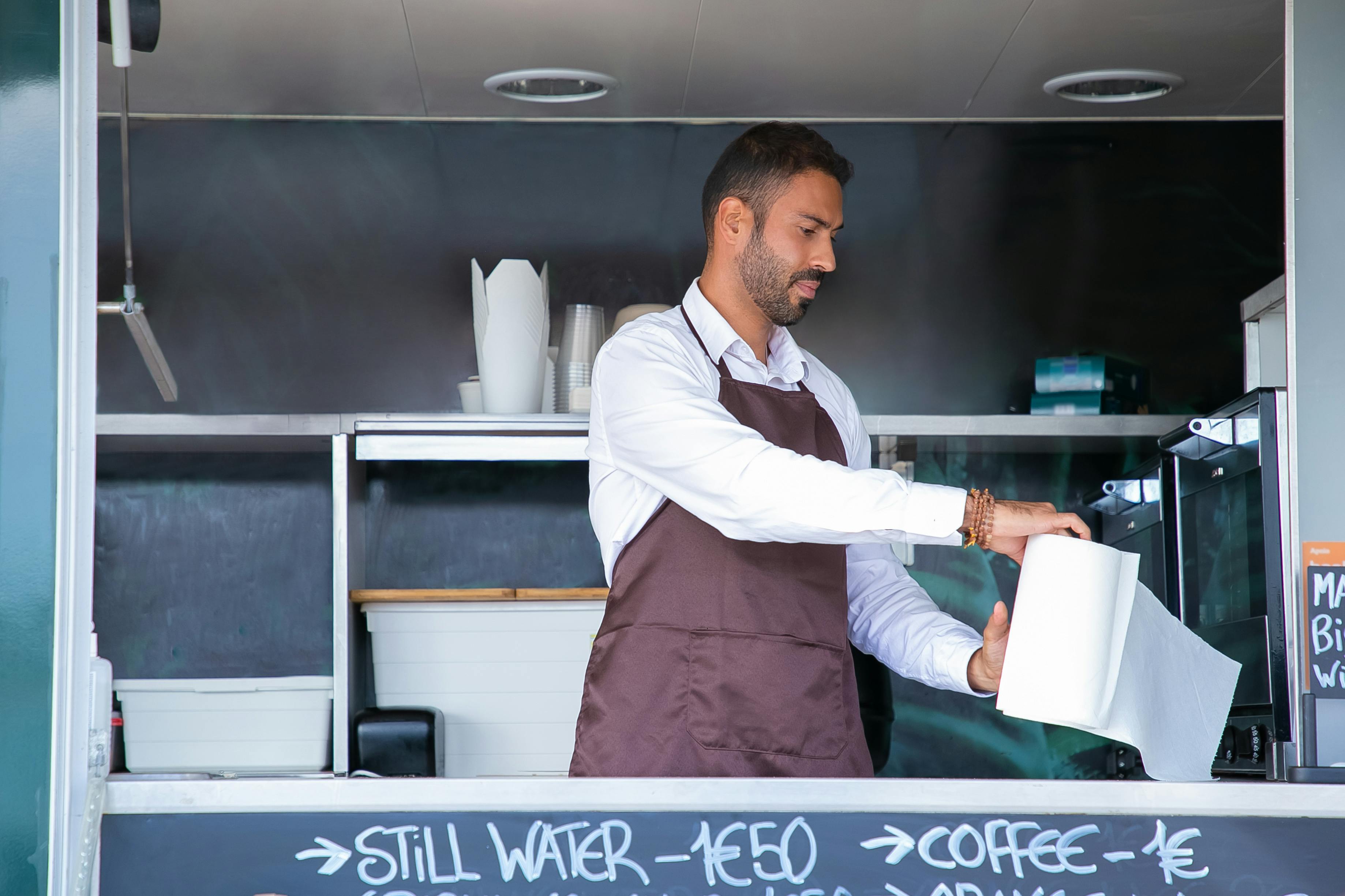 waiter standing at food truck counter with paper towel