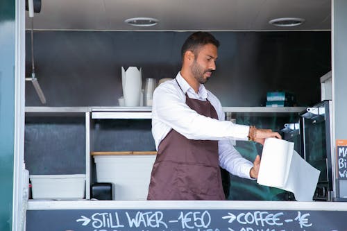 Waiter standing at food truck counter with paper towel