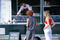 Ethnic seller suggesting food to diverse clients
