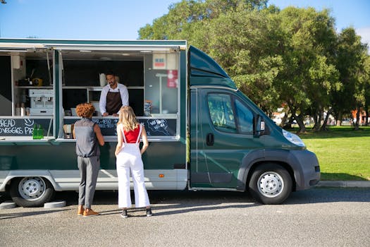 Customers ordering at a food truck parked in a sunny park, showcasing mobile dining.