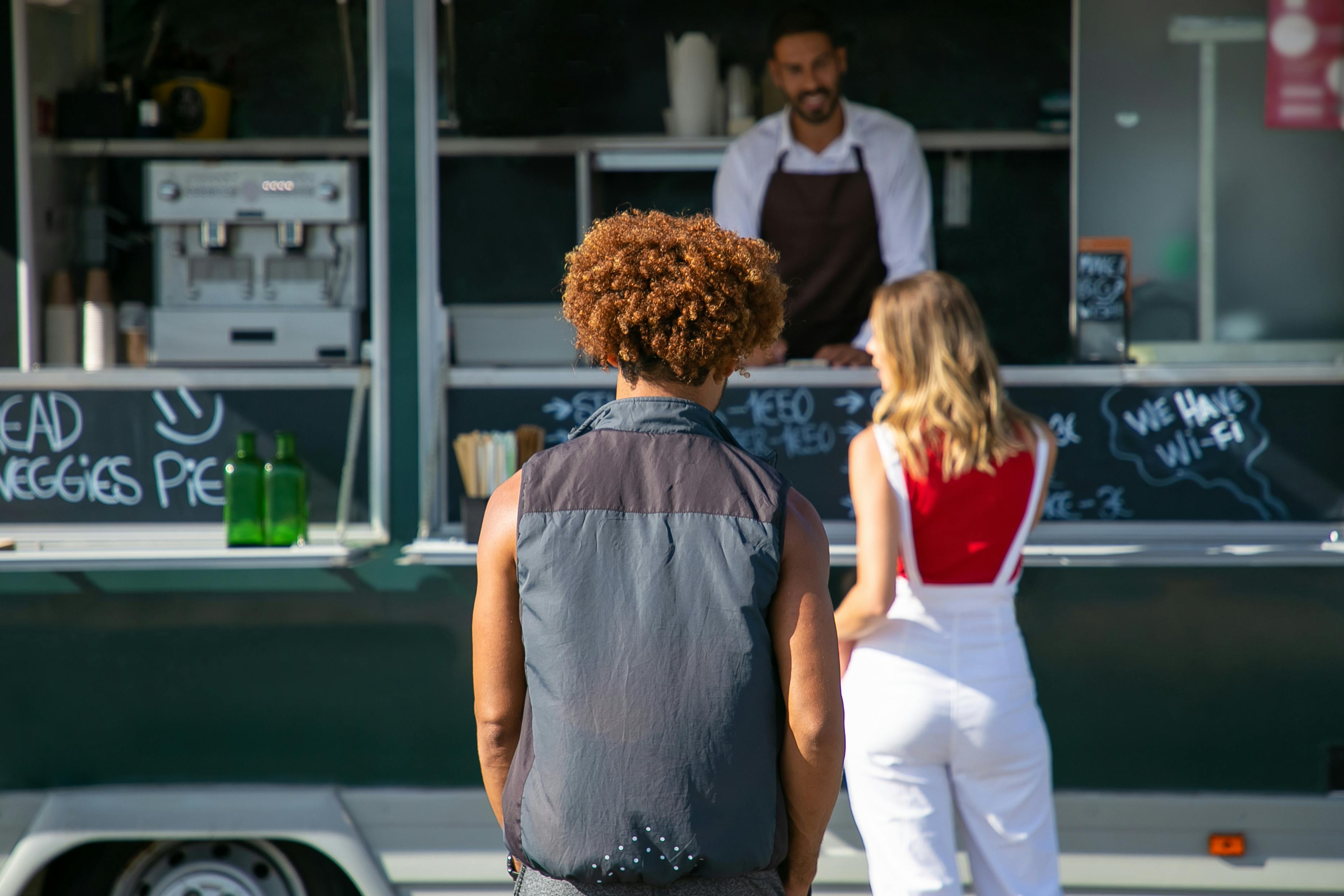 multiethnic friends selecting food at street food truck