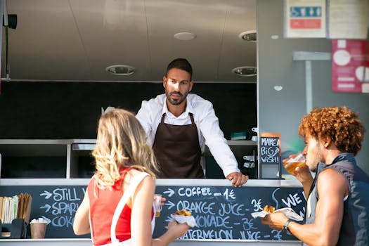 Street food vendor serves customers at a food truck, enjoying casual snacks and drinks.