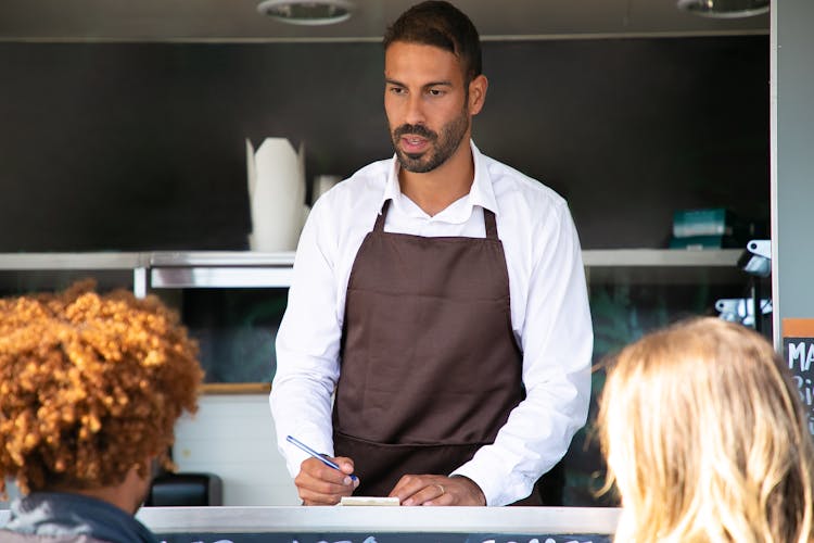 Serious Ethnic Male Chef Writing Order On Paper