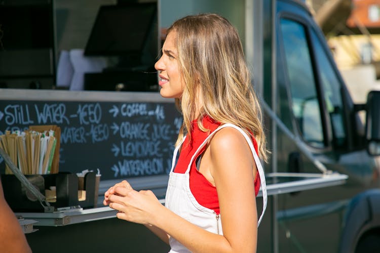 Young Woman Choosing Food At Street Food Counter