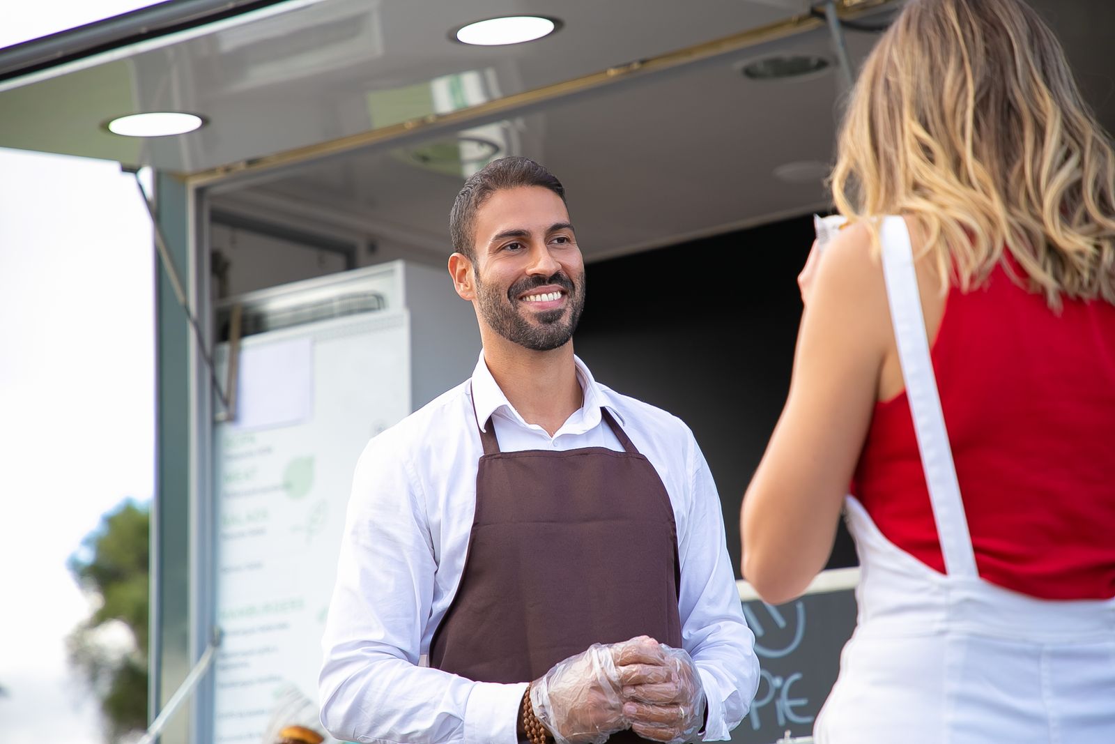 Food truck vendor serving a customer at the hatch