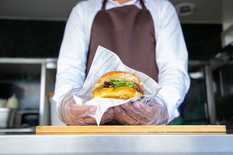 Cook handing a burger out of a catering food truck