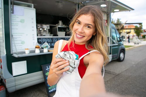 Free 甜甜圈與食物卡車附近採取自拍照的魅力女人 Stock Photo