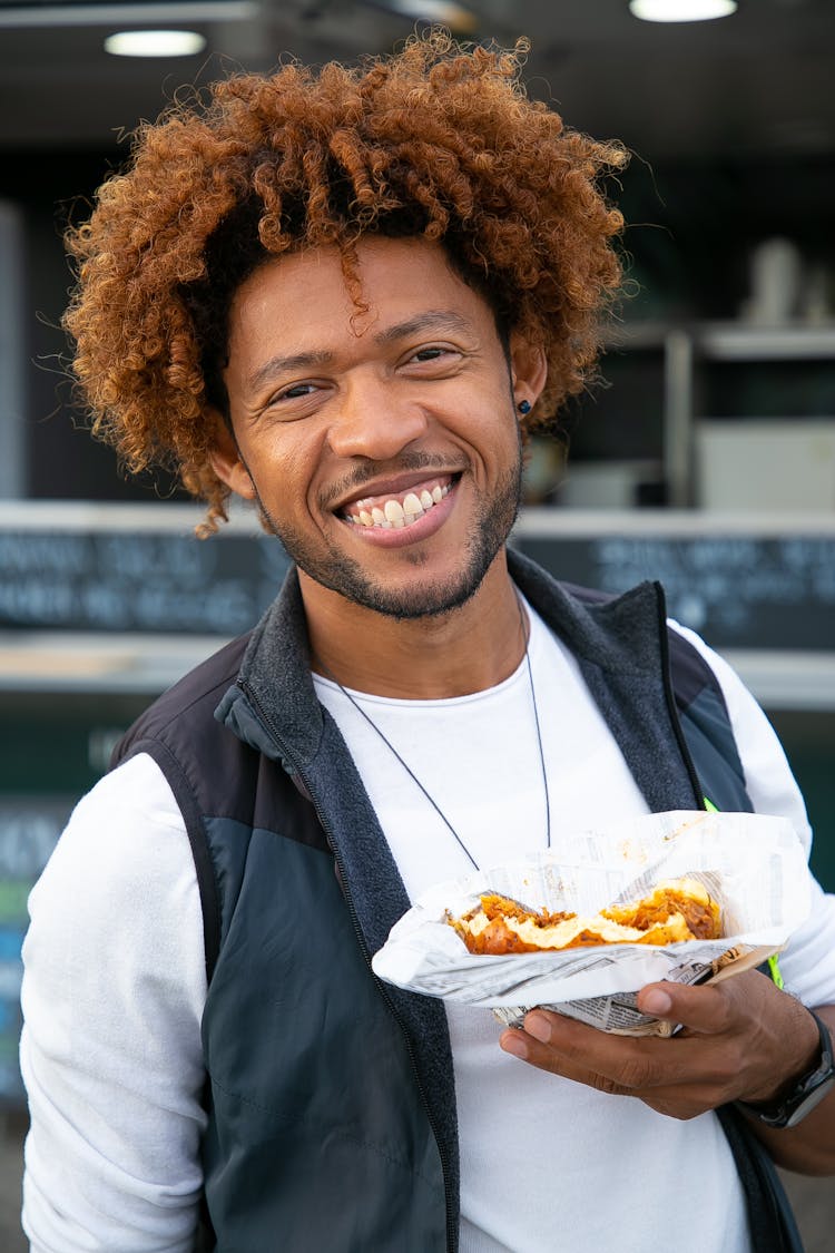 Happy Black Man Enjoying Sandwich In Outdoor Cafe