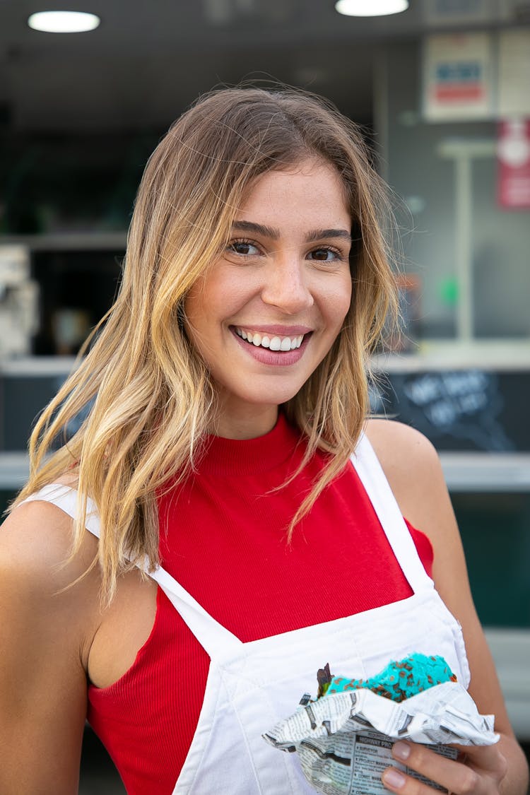 Cheerful Woman With Burger Standing Against Food Truck