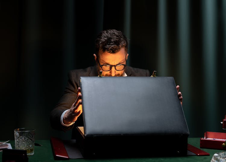 A Man Looking Inside An Open Briefcase