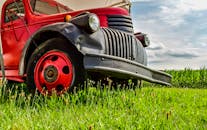 一辆经典的红色卡车停在乡村的绿色田野上