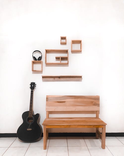 Black Acoustic Guitar and a Brown Wooden Bench