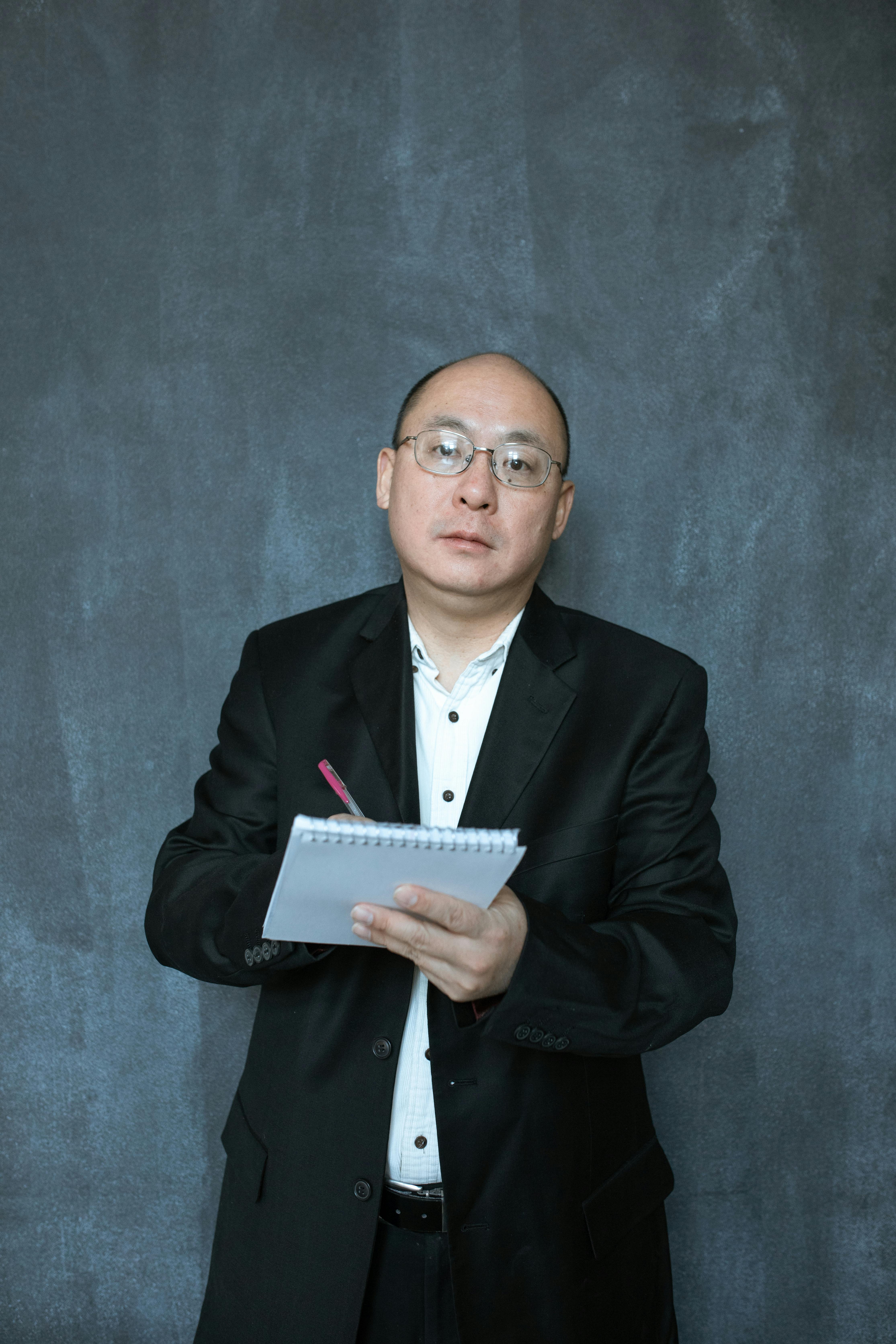 man in black suit holding white box