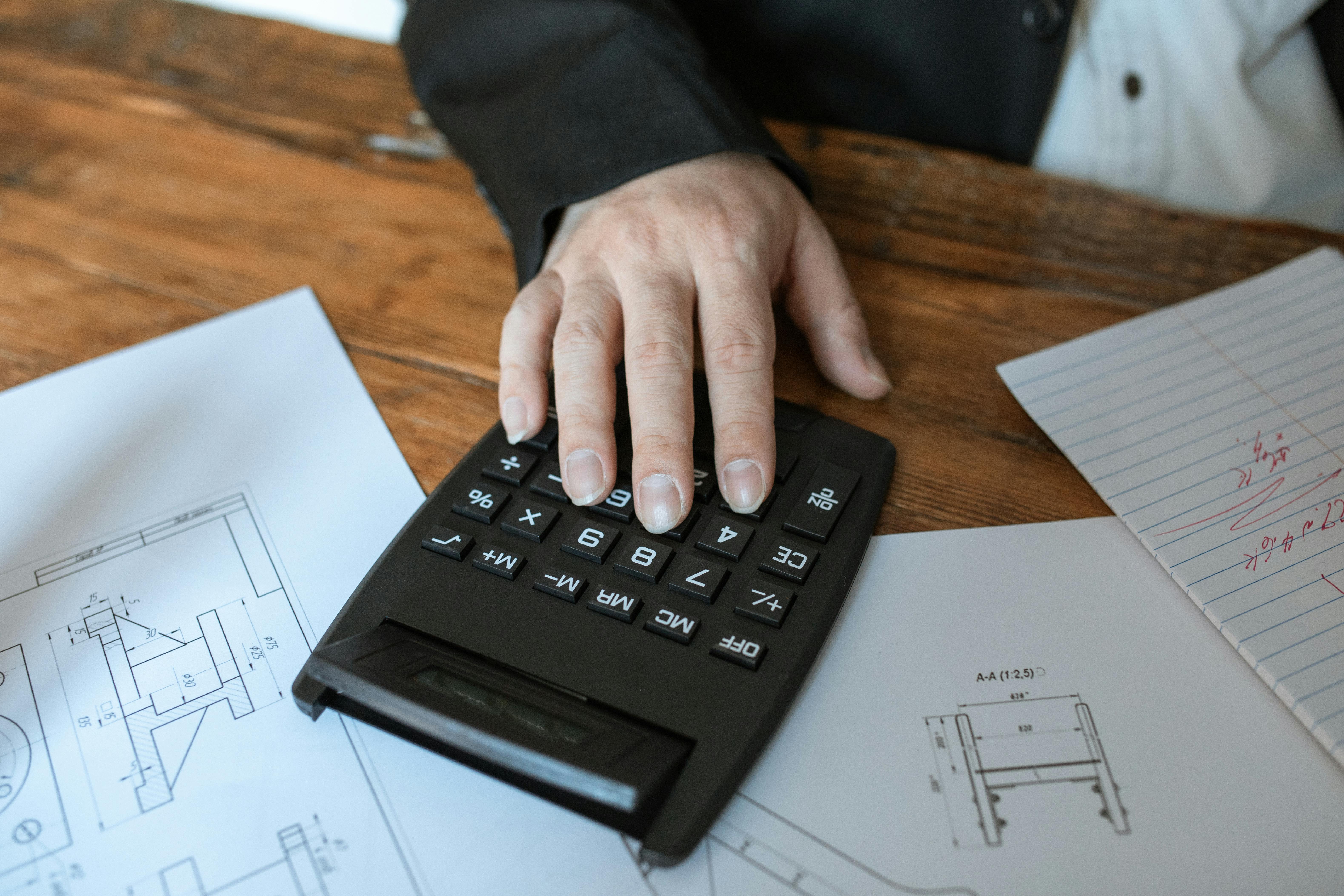 person holding black desk calculator