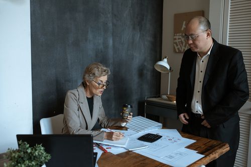 Free Senior professionals collaborate in a modern office setting. Includes documents and discussions. Stock Photo