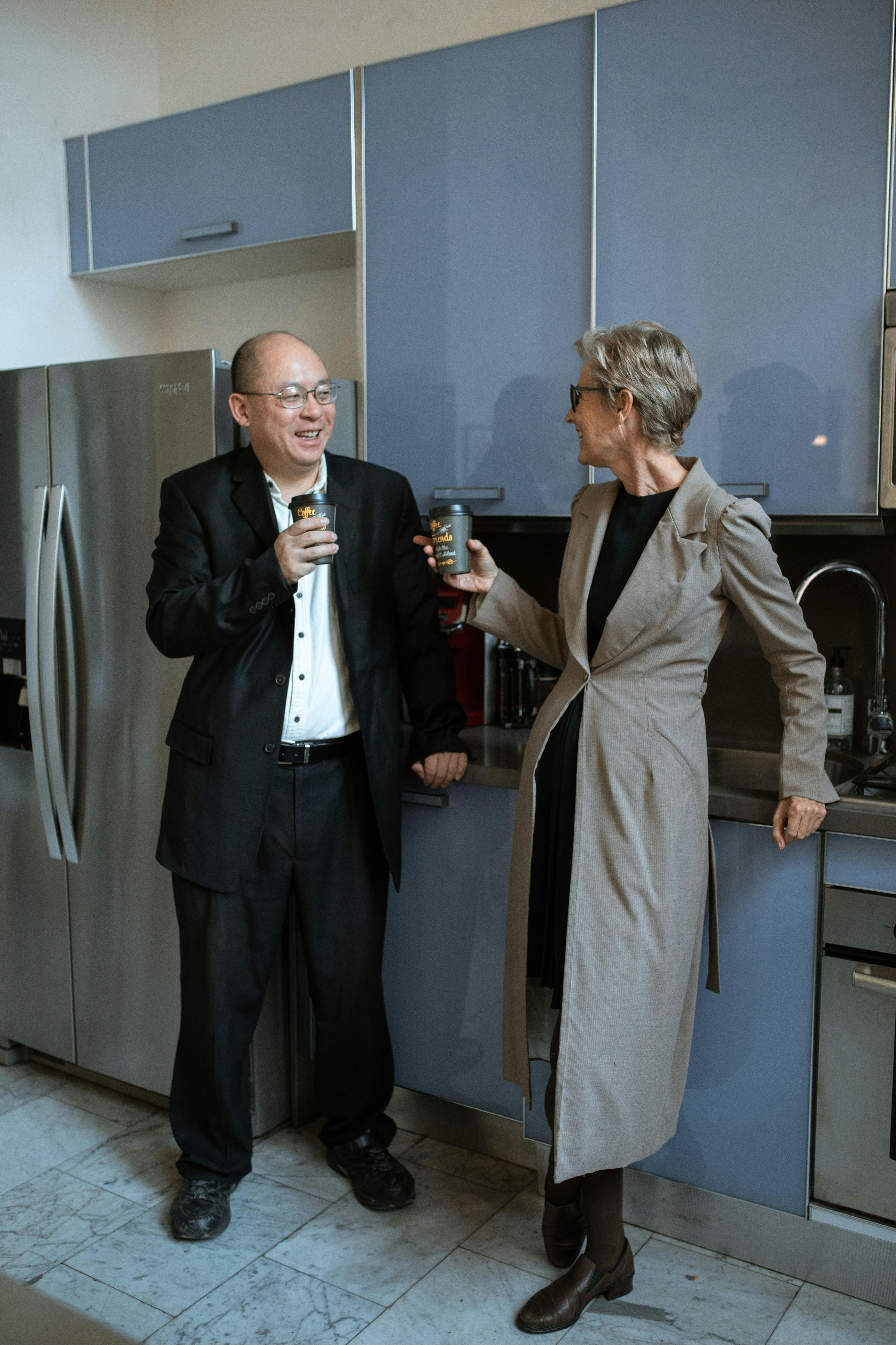 man in black suit standing beside woman in gray coat