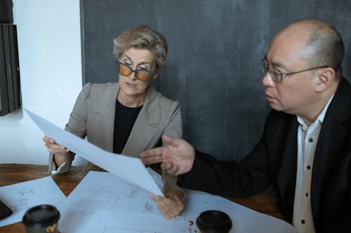 Business Partners Sitting at a Desk Looking at Papers  