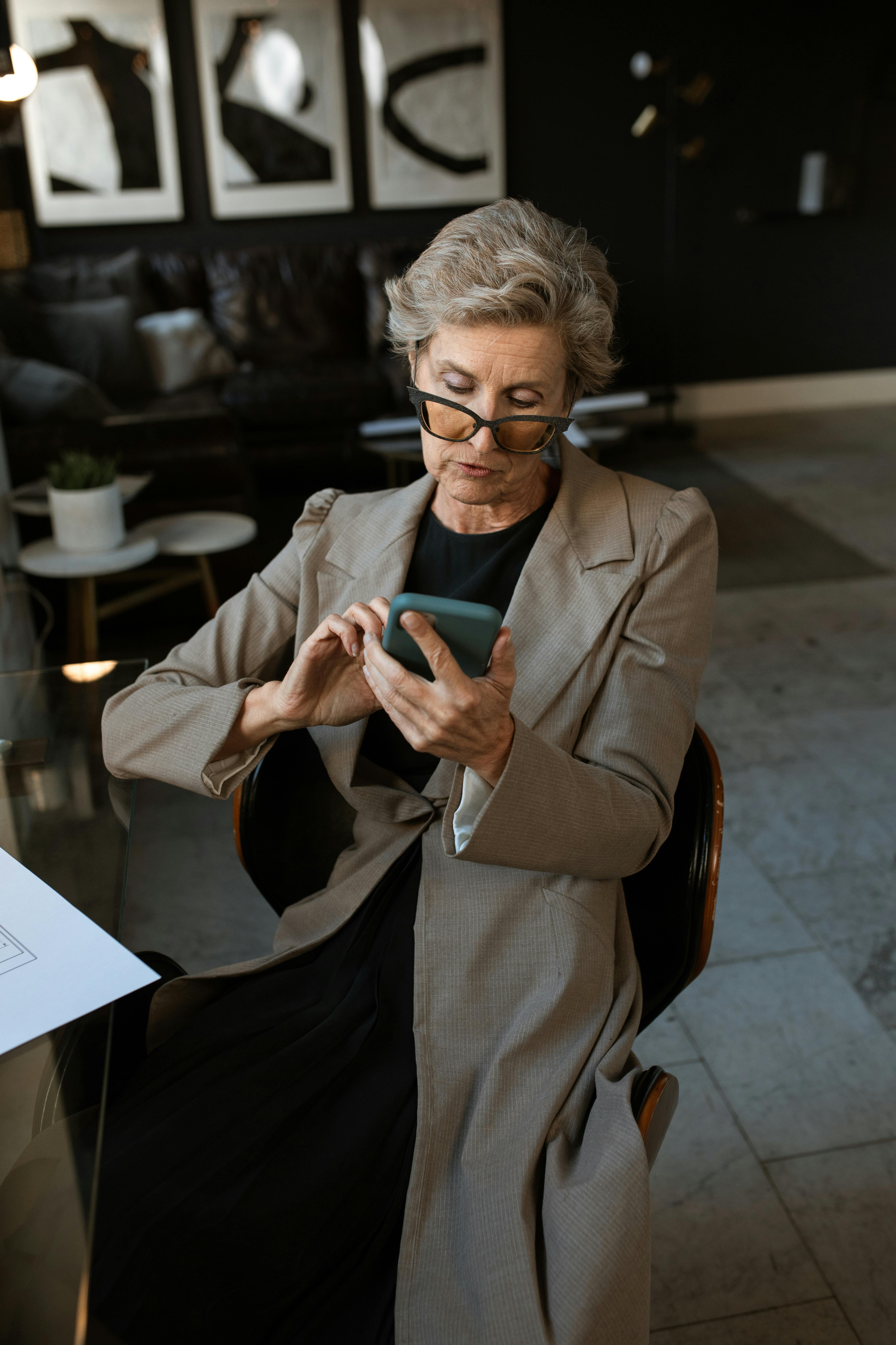 man in brown suit jacket holding smartphone