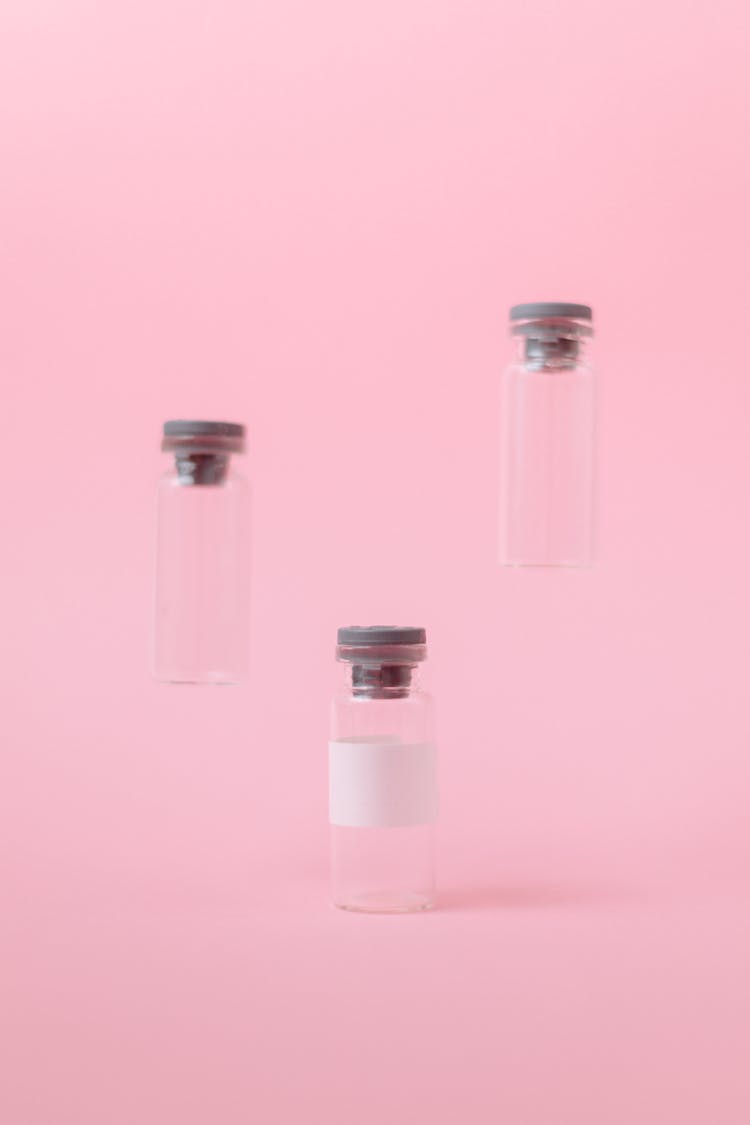 Three Empty Vials On Pink Surface