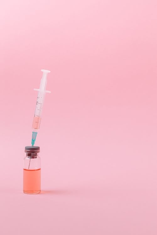 Free Covid Vaccine on Pink Surface Stock Photo