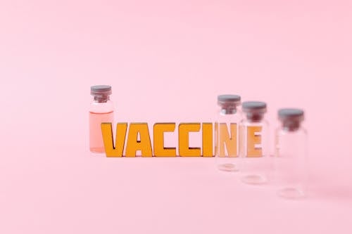 Free Vaccine Text Beside Empty Clear Glass Vials Stock Photo