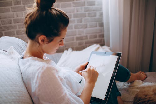 Free Young woman using stylus with tablet Stock Photo