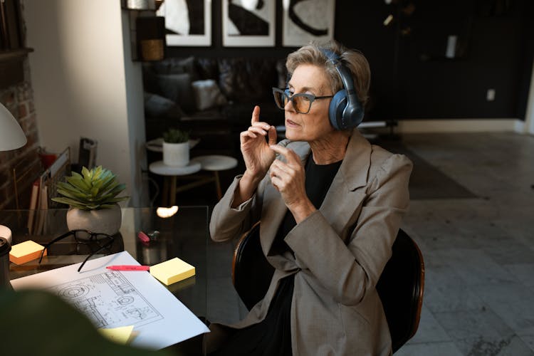 Elderly Woman In Brown Coat Wearing Blue Headset