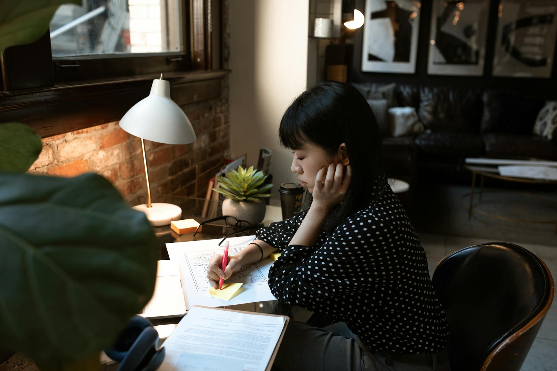 Woman Writing on a Sticky Note