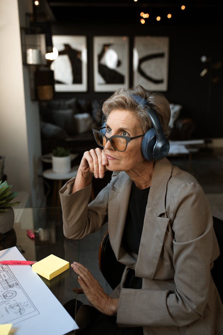 Elderly Woman In Brown Coat Wearing Blue Headset