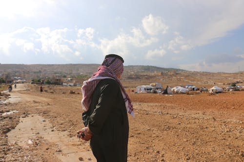 Man in traditional Muslim wear standing in refugee camp