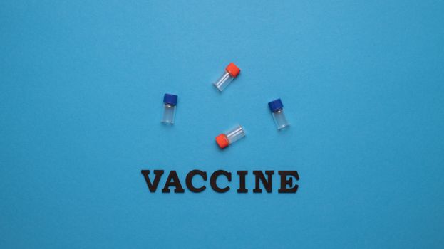 蓝色背景上的三个小瓶和“疫苗”一词，代表疫苗接种和健康