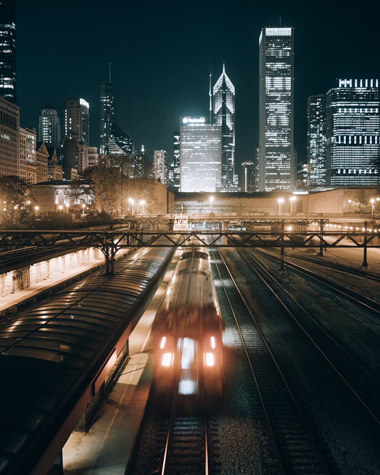 Train Near City Buildings During Night Time