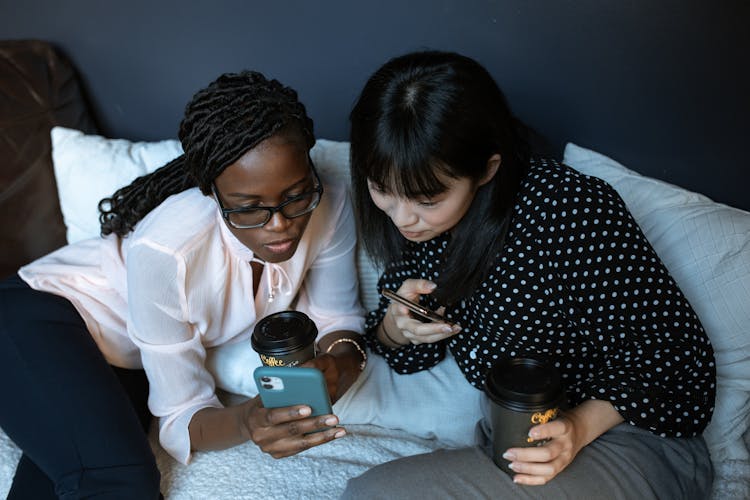 Photograph Of Friends Looking At A Cell Phone