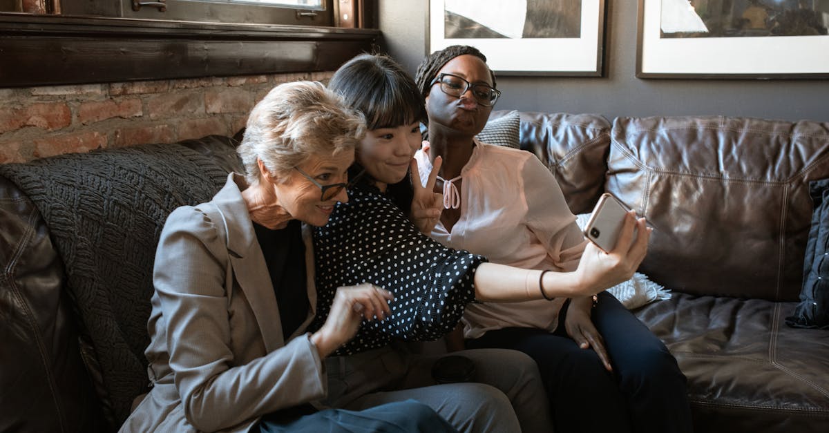A group of diverse friends enjoying a selfie together on a cozy couch in a stylish interior.