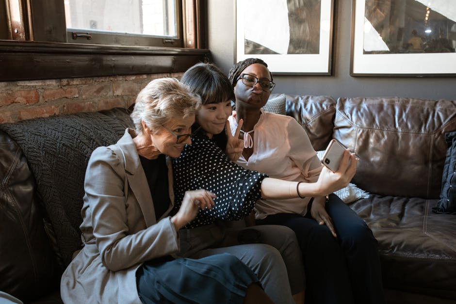 A group of diverse friends enjoying a selfie together on a cozy couch in a stylish interior.