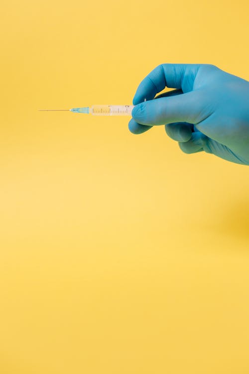 Free Person Holding A Syringe Stock Photo