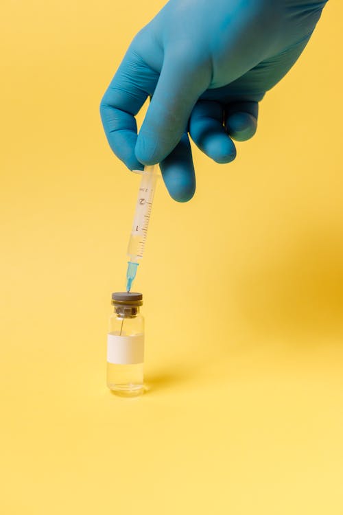 вакцина Covid на желтой поверхности