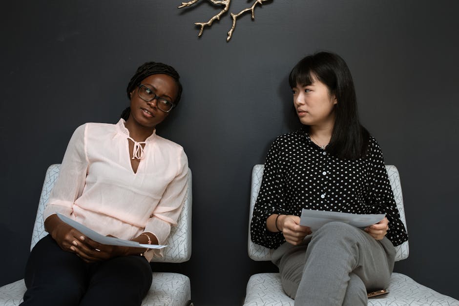 Two businesswomen having a discussion in a sleek, modern office setting.