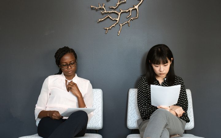 Two women sitting in an office, preparing for interviews.