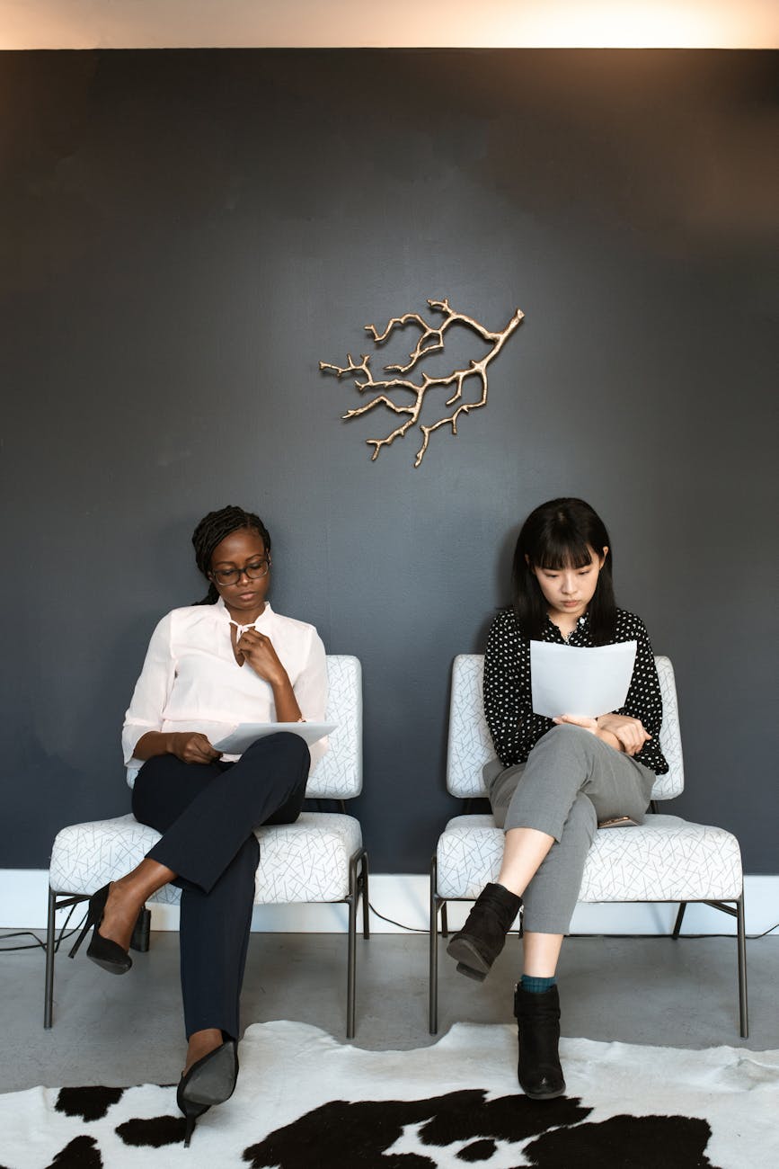 Two women sitting in an office, preparing for interviews.