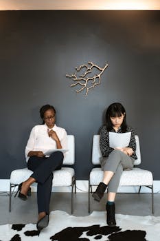 Two women sitting in an office, preparing for interviews.