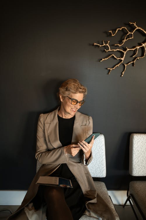 Free A Woman in Brown Blazer Sitting on White Chair Stock Photo