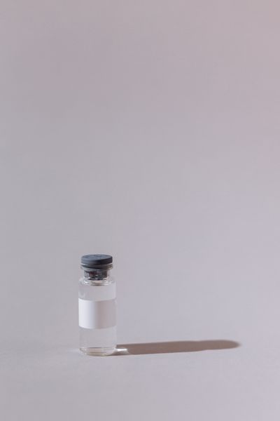 Single sealed glass medication vial on a neutral studio backdrop — photo by Thirdman on Pexels