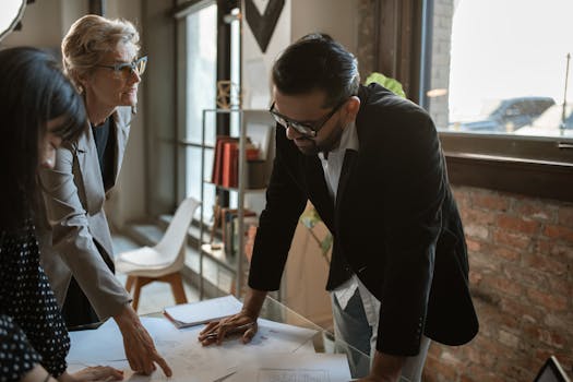 Business professionals discussing documents during a meeting in a stylish, light-filled office.