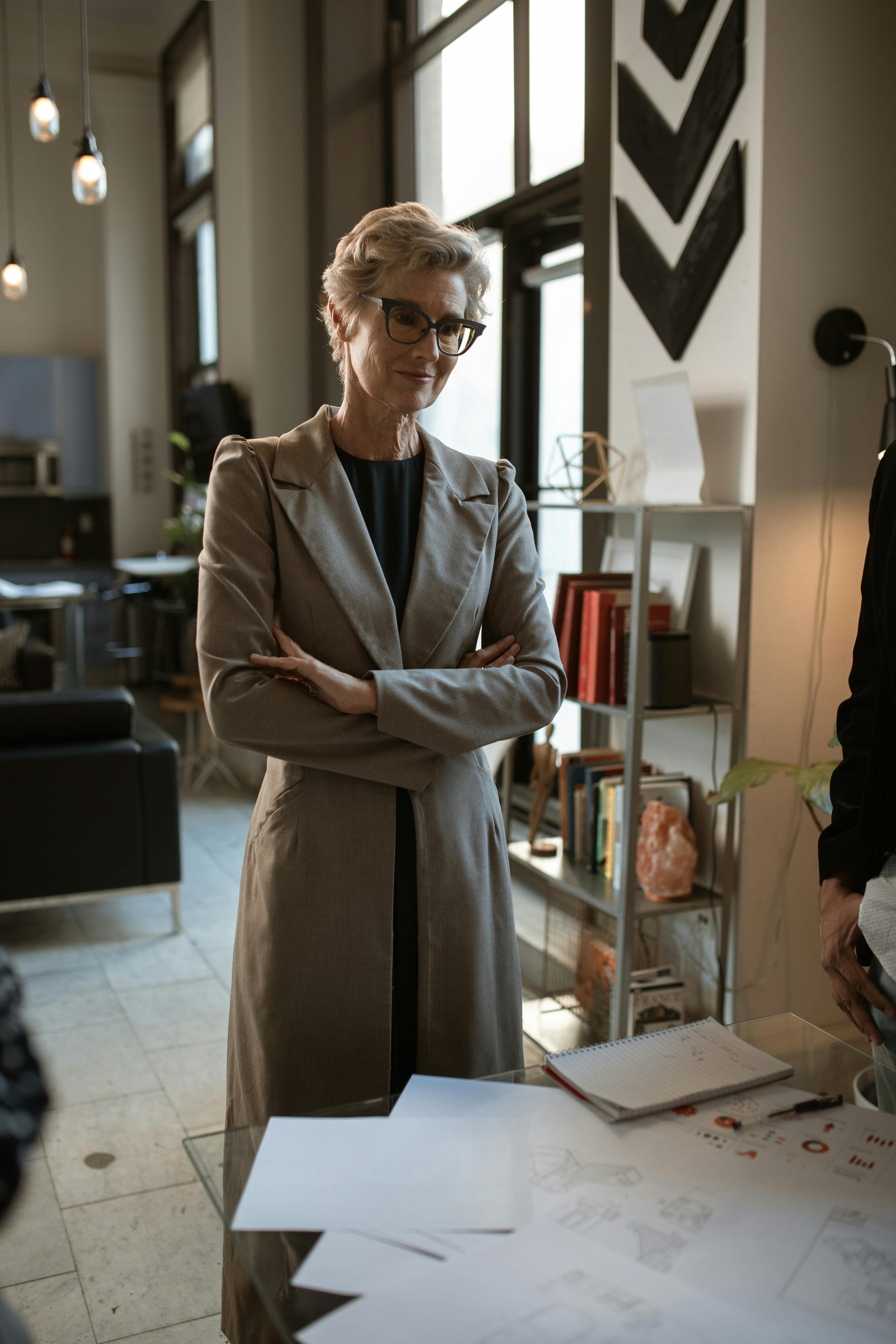 woman in brown coat standing near white table