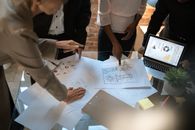 商务专业人士在现代办公桌上协作处理建筑图纸和图表