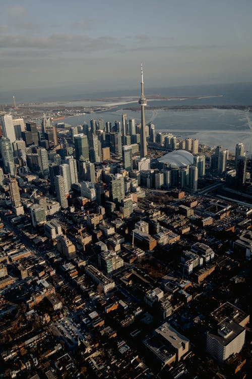 Aerial view of city district with skyscrapers and CN telecommunication Tower on coast of river in Canada