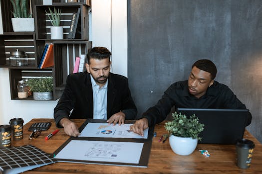 Two businessmen collaborating over financial charts in a modern office setting.